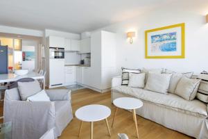 ein Wohnzimmer mit einem Sofa und einem Tisch in der Unterkunft Bright T2 with balcony and sea view in Biarritz in Biarritz
