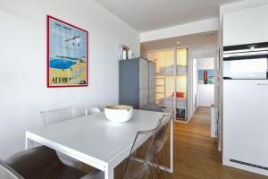 eine Küche und ein Esszimmer mit einem weißen Tisch und Stühlen in der Unterkunft Bright T2 with balcony and sea view in Biarritz in Biarritz