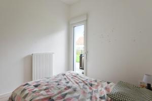 een witte slaapkamer met een bed en een raam bij Spacious 3-rooms with garden close to Lille in Lille