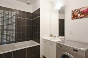 a bathroom with a sink and a washing machine at Spacious 3-rooms with garden close to Lille in Lille