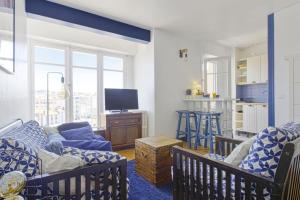 a living room with a couch and a tv at Studio Thalmar - Welkeys in Biarritz