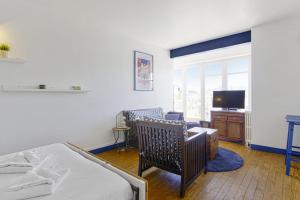 a bedroom with a bed and a living room with a tv at Studio Thalmar - Welkeys in Biarritz