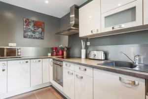 una cucina con armadi bianchi e lavandino di Appartement Oasis - Welkeys a Antibes