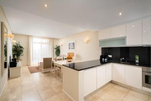 a kitchen with white cabinets and a dining room at Monte Santo Resort in Carvoeiro