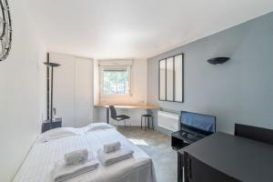 een slaapkamer met een bed, een tafel en een bureau bij Bright and modern studio close to Part-Dieu - Welkeys in Lyon