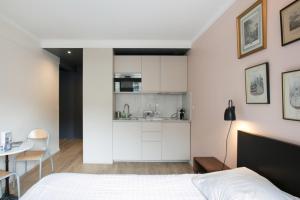 Cet appartement comprend une chambre avec un lit et une table ainsi qu'une cuisine. dans l'établissement Cozy studio 10 min from Eiffel Tower Invalides Beaugrenelle, à Paris