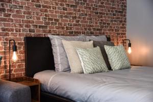 a bedroom with a brick wall and a bed with pillows at Nice and modern studio in the heart of Annecy in Annecy