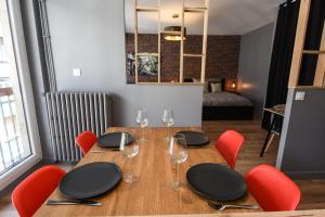 a wooden table with red chairs and wine glasses at Nice and modern studio in the heart of Annecy in Annecy