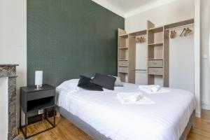 ein Schlafzimmer mit einem weißen Bett und einer grünen Wand in der Unterkunft Large apartment on Bayonne city-center - Welkeys in Bayonne