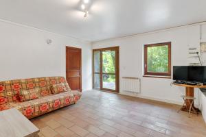 a living room with a couch and a tv at Modern studio in a nice farm close to city-center - Welkeys in Annecy