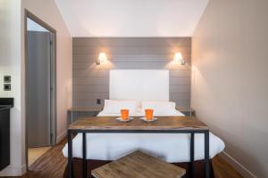 Zimmer mit einem Bett mit zwei Gläsern auf dem Tisch in der Unterkunft Beffroi - Cosy studio close to Vieux Lille - Welkeys in Lille