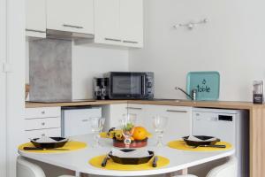 una cocina con una mesa con un bol de fruta. en Nice studio with balcony and parking in Villeurbanne near Lyon - Welkeys, en Villeurbanne