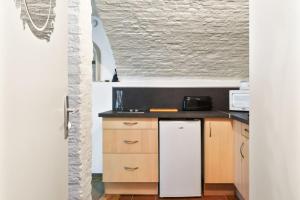 a kitchen with a white refrigerator and a counter at Atypical and cozy studio in Old Lille close to the station - Welkeys in Lille