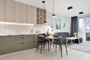 a kitchen and dining room with a table and chairs at Apartament Premium Platany by Renters in Kołobrzeg