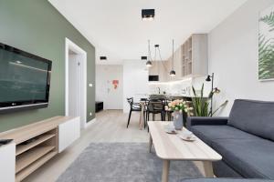 a living room with a couch and a table at Apartament Premium Platany by Renters in Kołobrzeg