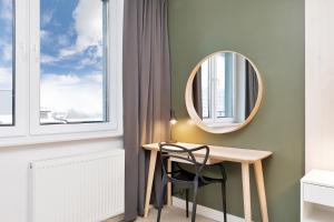 a room with a table and a mirror on the wall at Apartament Premium Platany by Renters in Kołobrzeg