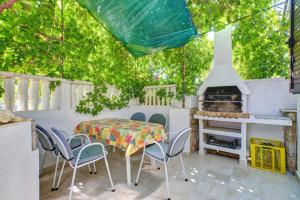 a patio with a table and chairs and a fireplace at Apartment Goga - Seaview & Parking in Mali Lošinj