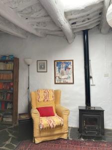 a living room with a chair and a stove at Casa Barbara in Ferreirola