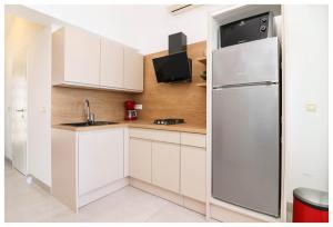 a kitchen with white cabinets and a refrigerator at Apartment Jerko 2 in Primošten