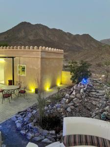 a patio with a table and chairs and a stone yard at Alshahad farmhouse in Fujairah