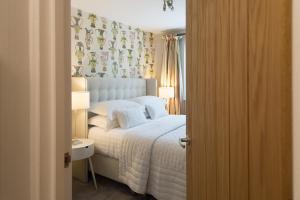a bedroom with a white bed and a window at The Mews, York Place by Harrogate Serviced Apartments in Harrogate