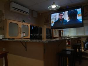 a bar with a flat screen tv on the wall at VIRGINIA TOWNHOUSE in East London