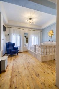 - une chambre avec un grand lit et une chaise bleue dans l'établissement Bastion Luxury Medieval Accommodation, à Rhodes