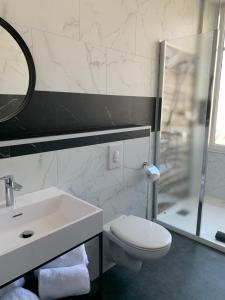 La salle de bains est pourvue de toilettes, d'un lavabo et d'une douche. dans l'établissement La Maison Bleue « La Charade », à Thaon-les-Vosges
