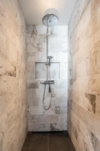 a bathroom with a shower with marble walls at Hosted by Wendy prins willem 2 in Scheveningen