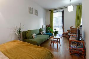 a living room with a green couch and a table at Negroni Apartments Stare Miasto in Krakow