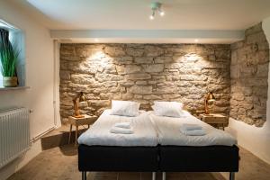Un dormitorio con una pared de piedra y una cama en Hotell Breda Blick en Visby
