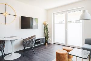 a white living room with a table and chairs at Dünenquartier Apartment 27 in Zingst
