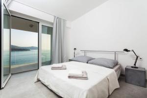 ヴェラ・ルカにあるVilla Style and Seaの大きなベッドと大きな窓のある寝室 +27枚の写真