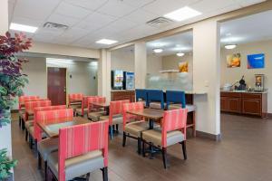 una sala de espera con mesas, sillas y un mostrador en Comfort Suites Miamisburg - Dayton South, en Miamisburg