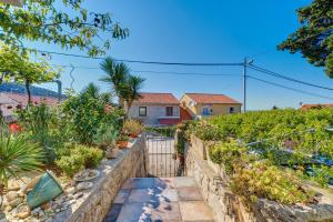 a house with a garden and a fence at Apartment Neno in Veli Lošinj