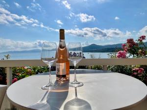 a bottle of wine and two wine glasses on a table at L’Ile Rousse les pieds dans l’eau in LʼÎle-Rousse