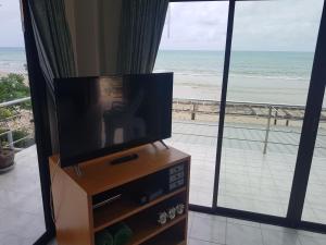 - une télévision sur un stand avec vue sur la plage dans l'établissement Kamala Dreams, à Kamala Beach