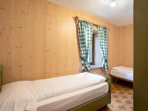 a small bedroom with a bed and a window at Ciasa Lino Sas da le Doudesc in Pozza di Fassa