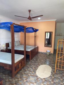 two bunk beds in a room with a blue wall at Highland Bungalows in Nungwi