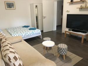 a living room with a couch and a flat screen tv at Bella apartman Balatonalmádi in Balatonalmádi