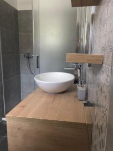 ein Badezimmer mit einem weißen Waschbecken auf einer Holztheke in der Unterkunft Apartments Nenich Aves in Žman