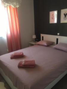 a bedroom with a large bed with two pillows on it at Apartments Nenich Aves in Žman