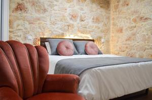 - une chambre avec un lit doté d'oreillers et d'une chaise dans l'établissement Casa GANCHINHO, à Santiago da Guarda