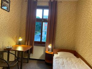 ビストシツァ・クウォツカにあるHotel i Restauracja Castleのベッドルーム1室(ベッド1台、テーブル、窓付)