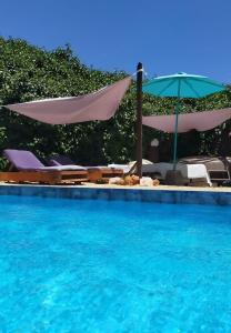 a swimming pool with chairs and an umbrella at Casa Francesca Altea piscina y aparcamiento privado in Altea