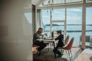 duas pessoas sentadas numa mesa a jogar xadrez em Panorama Rorbusuiter em Steinsland
