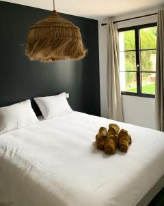 a white bed with two pairs of shoes on it at Les Jardins des Brandes in La Rochelle