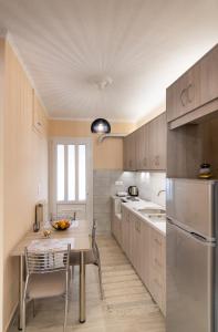 Marathos Apartment في ليفكادا تاون: مطبخ مع طاولة وكراسي ومطبخ مع حوض