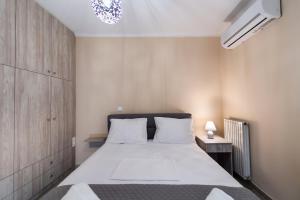 Marathos Apartment في ليفكادا تاون: غرفة نوم مع سرير أبيض كبير في غرفة
