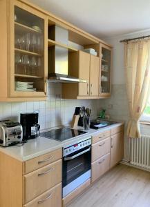 a kitchen with wooden cabinets and a stove top oven at Casa Mika in Konstanz